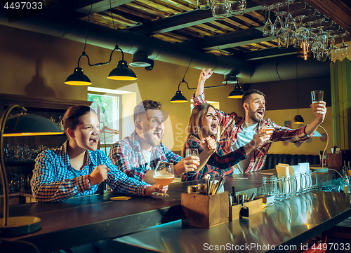 Image of Sport, people, leisure, friendship and entertainment concept - happy football fans or male friends drinking beer and celebrating victory at bar or pub