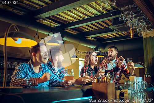 Image of Sport, people, leisure, friendship and entertainment concept - happy football fans or male friends drinking beer and celebrating victory at bar or pub