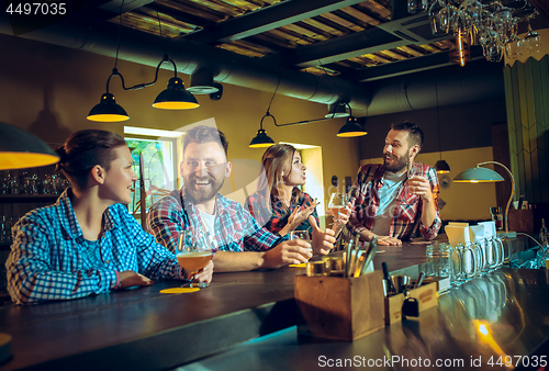 Image of Sport, people, leisure, friendship and entertainment concept - happy football fans or male friends drinking beer and celebrating victory at bar or pub