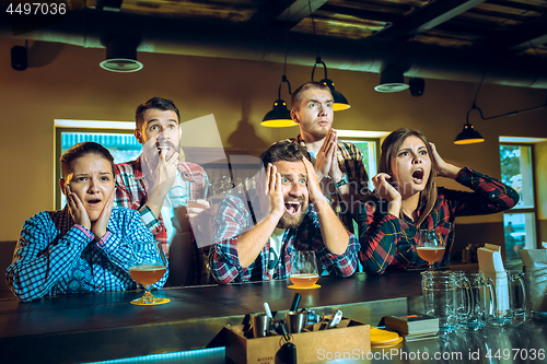 Image of Sport, people, leisure, friendship and entertainment concept - happy football fans or male friends drinking beer and celebrating victory at bar or pub