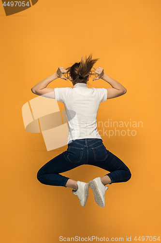 Image of Closeup of young woman\'s body in empty white t-shirt on orange background. Mock up for disign concept