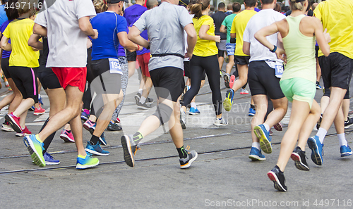 Image of Marathon runners running race people feet on city road 