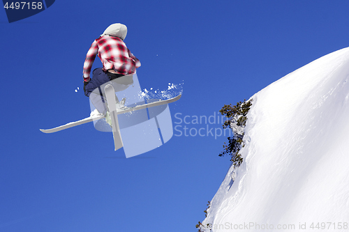 Image of Flying skier at jump inhigh on snowy mountains