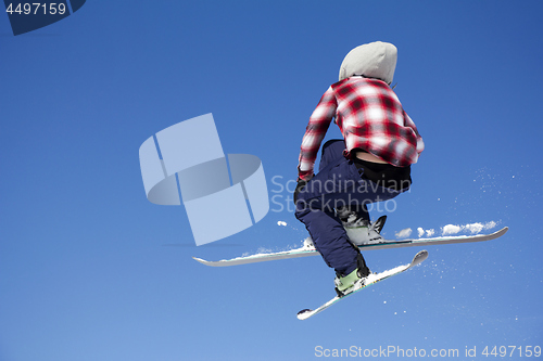 Image of Flying skier at jump inhigh on snowy mountains