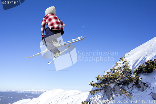 Image of Flying skier at jump inhigh on snowy mountains