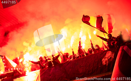 Image of football hooligans with mask holding torches in fire