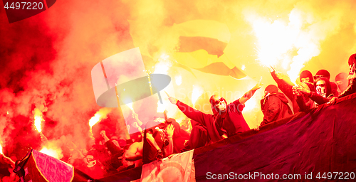 Image of football hooligans with mask holding torches in fire