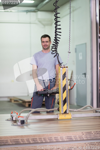 Image of worker in a factory of wooden furniture