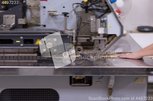 Image of engineer in front of wood cutting machine