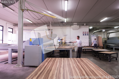 Image of worker in a factory of wooden furniture