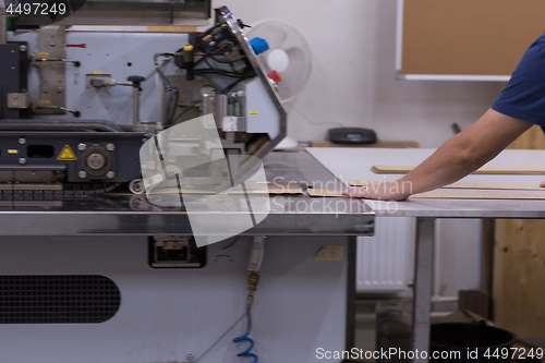 Image of engineer in front of wood cutting machine