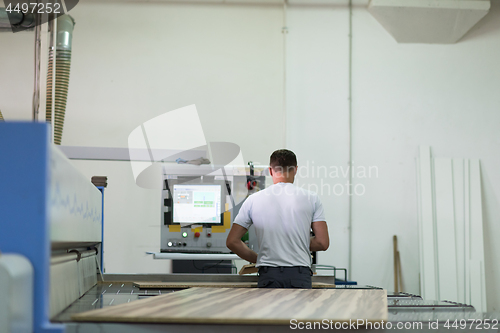 Image of worker in a factory of wooden furniture