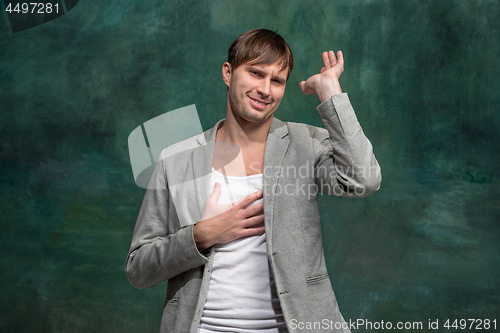 Image of Beautiful male half-length portrait at studio backgroud. The young emotional surprised man
