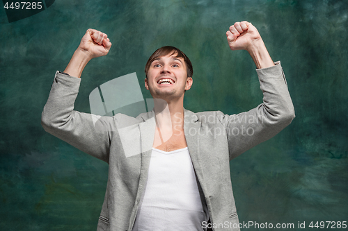 Image of Winning success man happy ecstatic celebrating being a winner. Dynamic energetic image of male model