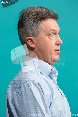 Image of The senior attractive man looking suprised isolated on blue