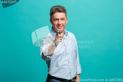 Image of The happy business man point you and want you, half length closeup portrait on blue background.