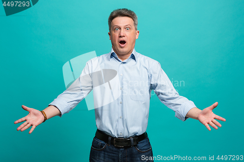 Image of The attractive man looking suprised isolated on blue