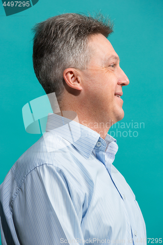 Image of The happy businessman standing and smiling against blue background.