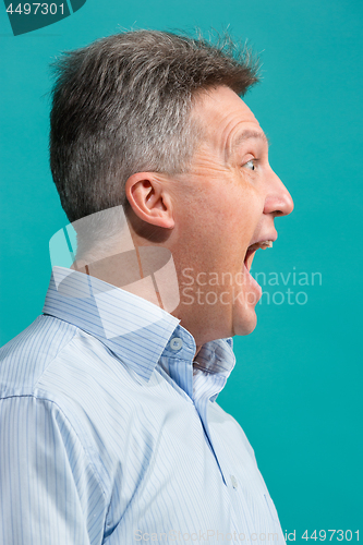 Image of The emotional angry man screaming on blue studio background