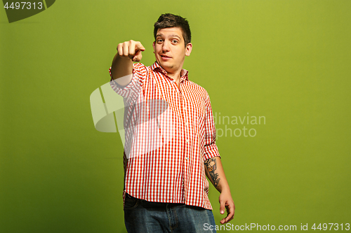 Image of The happy business man point you and want you, half length closeup portrait on green background.