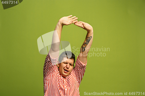 Image of Beautiful bored man isolated on green background