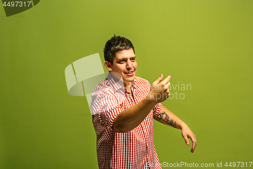 Image of Isolated on green young casual man shouting at studio