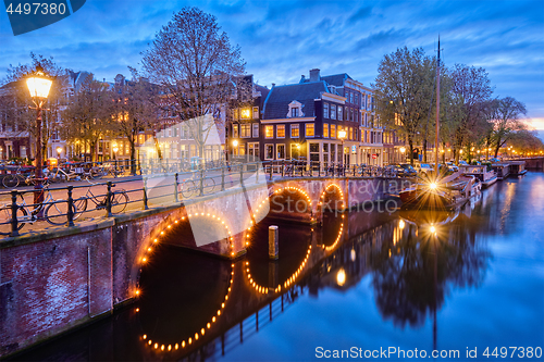 Image of Amterdam canal, bridge and medieval houses in the evening