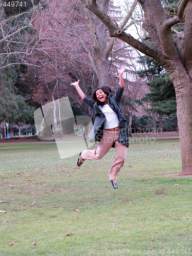 Image of Young hispanic teen girl jumping in park