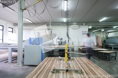 Image of worker in a factory of wooden furniture