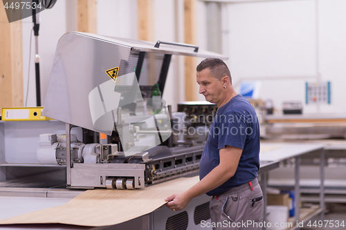 Image of worker in a factory of wooden furniture