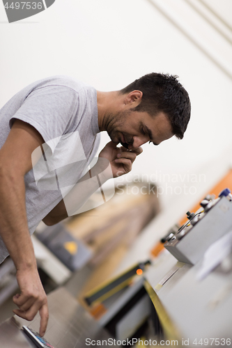 Image of engineer in front of wood cutting machine