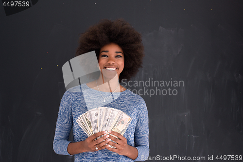 Image of black woman holding money on gray background