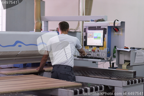 Image of worker in a factory of wooden furniture