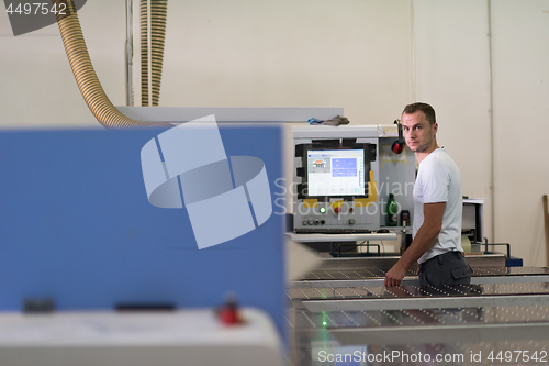 Image of worker in a factory of wooden furniture