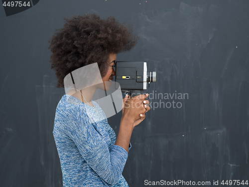 Image of african american woman using a retro video camera