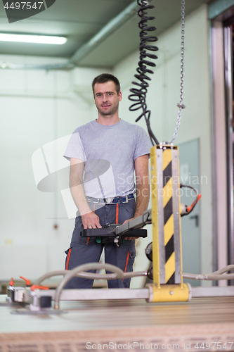 Image of worker in a factory of wooden furniture