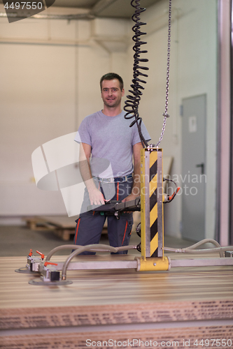Image of worker in a factory of wooden furniture