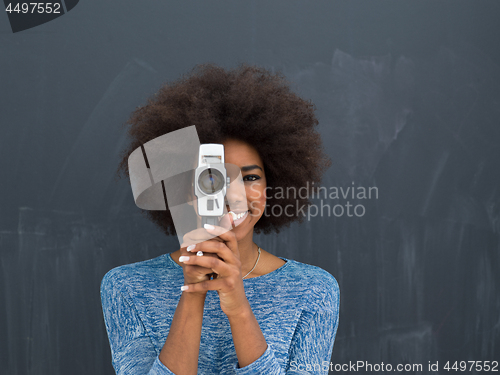 Image of african american woman using a retro video camera