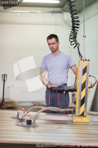 Image of worker in a factory of wooden furniture