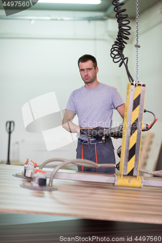 Image of worker in a factory of wooden furniture