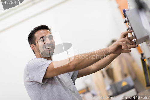 Image of worker in a factory of wooden furniture