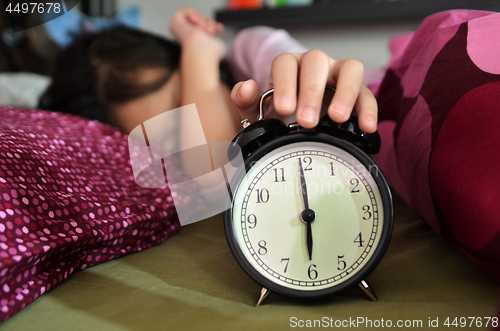 Image of Pretty girl sleeping on the background of a retro alarm clock