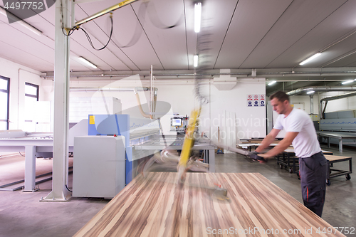 Image of worker in a factory of wooden furniture