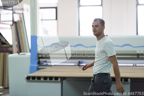 Image of worker in a factory of wooden furniture