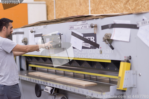 Image of worker in a factory of wooden furniture