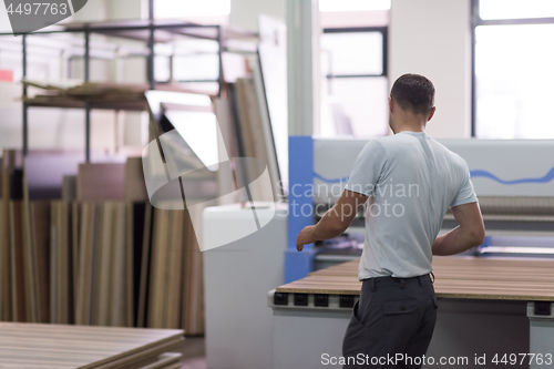 Image of worker in a factory of wooden furniture