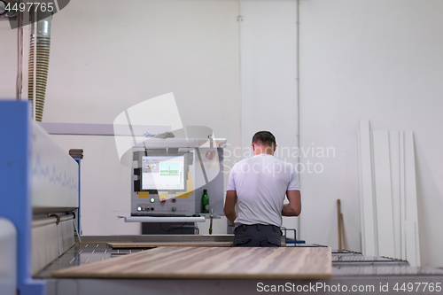 Image of worker in a factory of wooden furniture