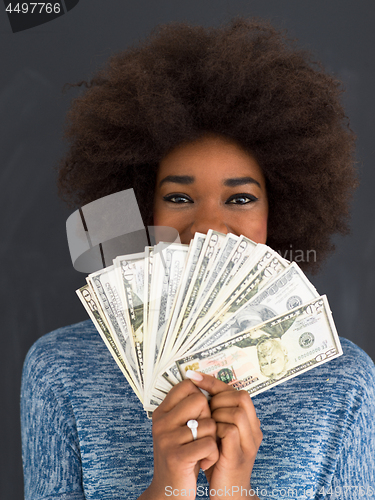 Image of black woman holding money on gray background