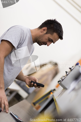 Image of engineer in front of wood cutting machine