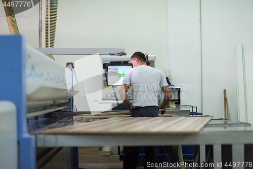 Image of worker in a factory of wooden furniture